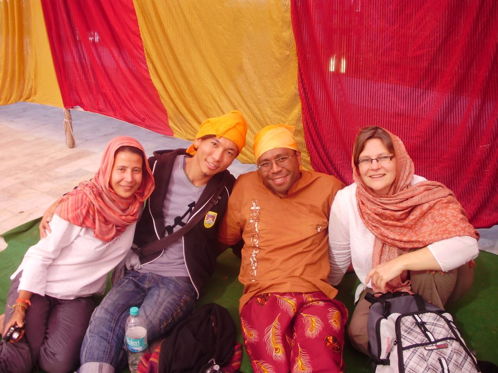 Photograph of author sitting on floor of Sikh temple with three other people from around the world